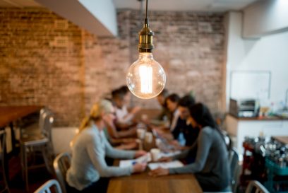 Business meeting in an energy-efficient NYC office space with a LED bulb in the foreground.