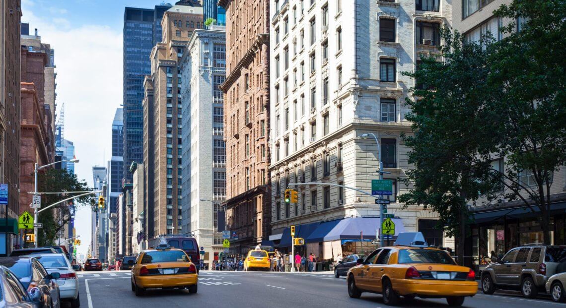 NYC street scene with skyscrapers, reflecting factors influencing Manhattan office space prices.