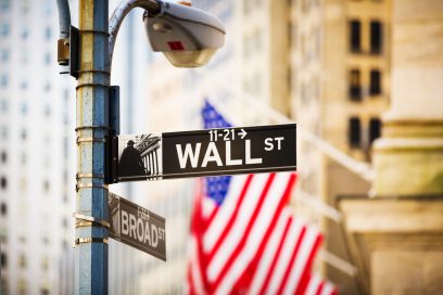 Wall Street sign against New York Stock Exchange in Lower Manhattan