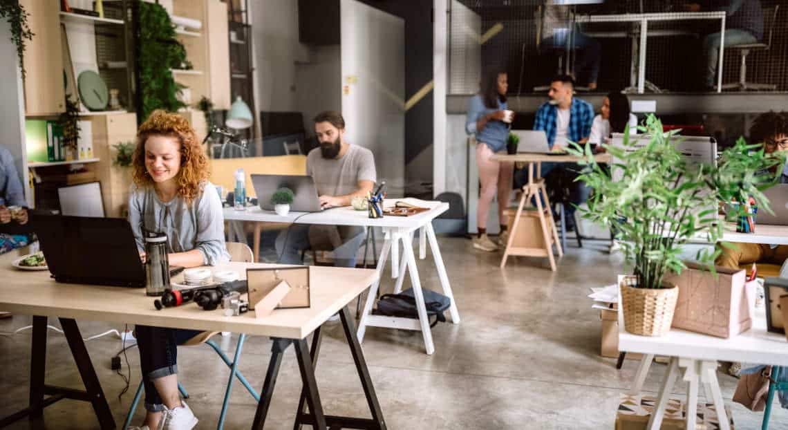 Young woman working happily in a comfortable NYC startup office