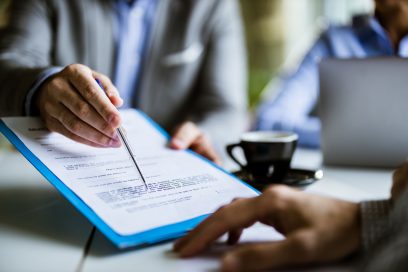 Businessman attentively reviewing and preparing to sign a commercial real estate lease contract.