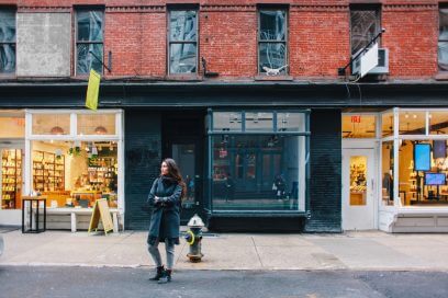 Woman exploring Soho street in Manhattan, surrounded by unique retail spaces for lease.