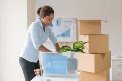 Latin American businesswoman happily packing boxes for a seamless office move in NYC.