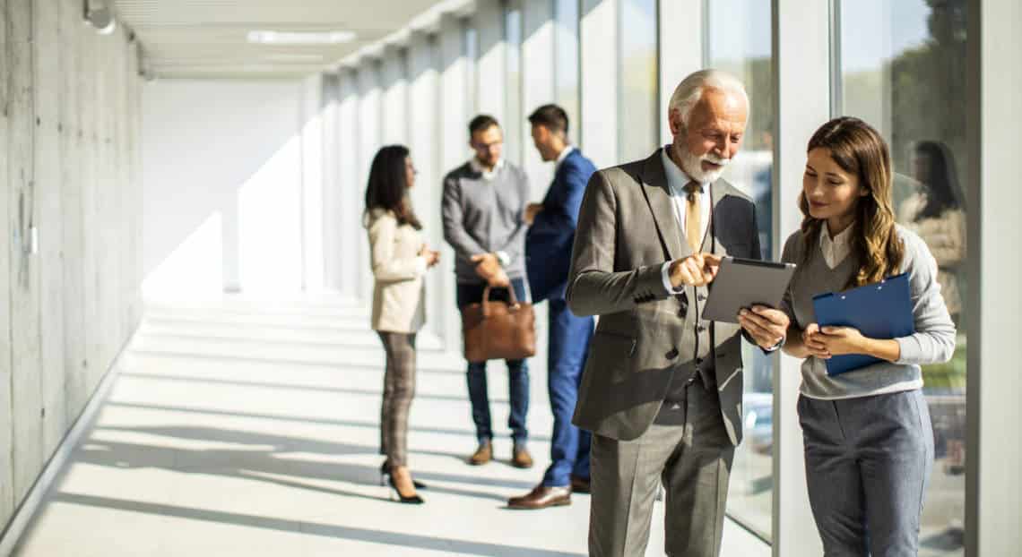 Business professionals networking in a modern NYC office building lobby.