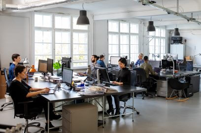 Productive open-plan office with workers, a choice for NYC commercial space search.