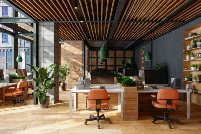 Open plan modern NYC office space with tables, chairs, pendant lights, and plants.