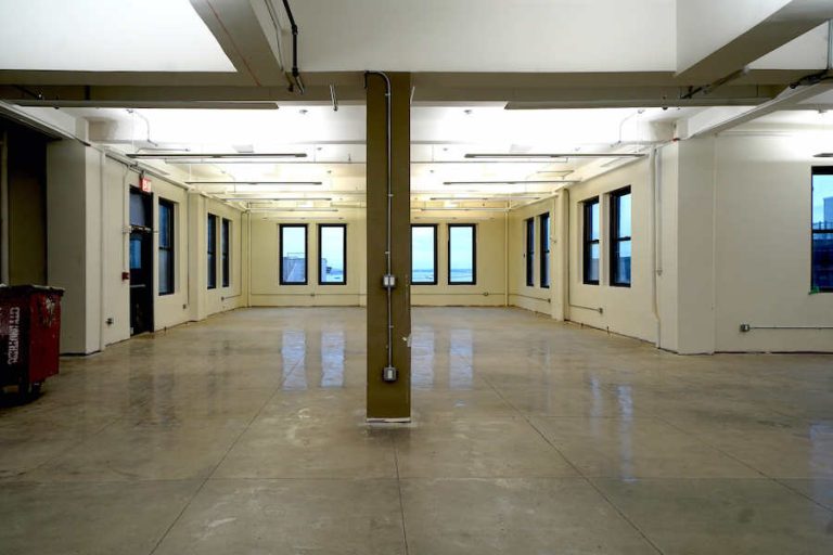 11 Broadway, 18th Floor, A spacious, empty room with white walls and a polished concrete floor.