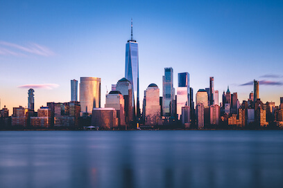 Lower Manhattan skyline from New Jersey at dusk, reflecting NYC commercial real estate trends.