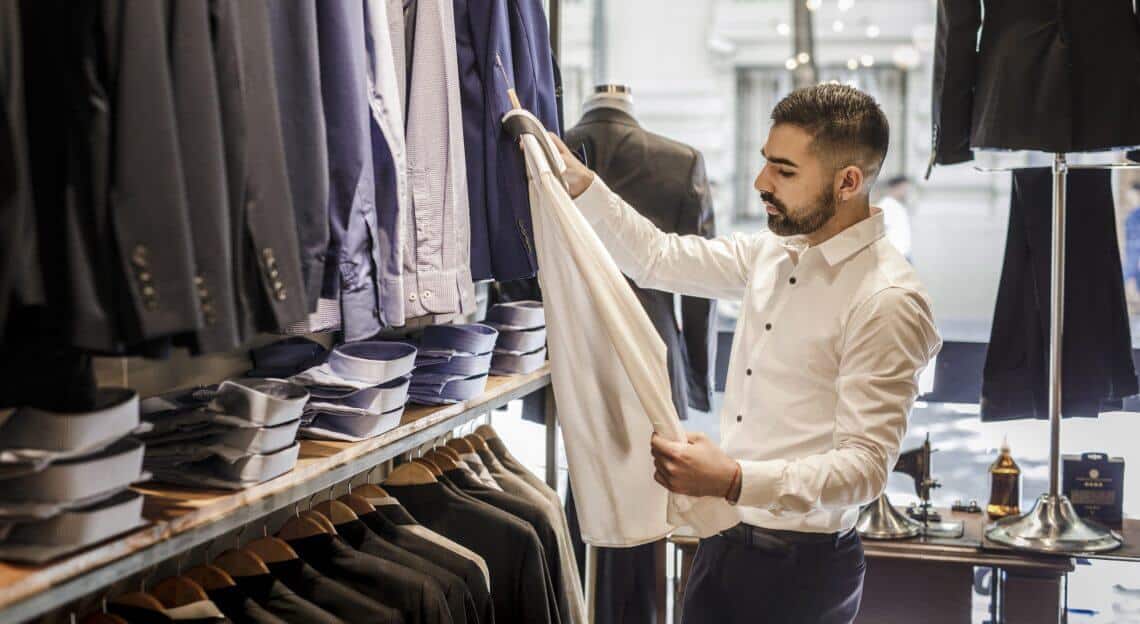 Young businessman browsing shirts in an NYC shop.