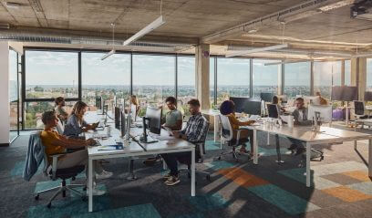 Programmers collaborating in a modern NYC office, reflecting WeWork's positive trajectory.