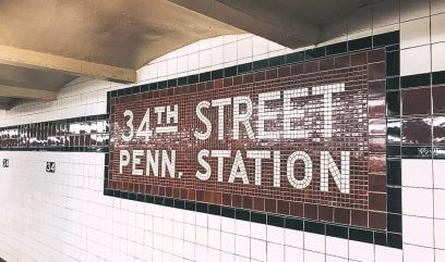 34th Street subway station with iconic red and white wall tiles, part of NYC's transit landscape.