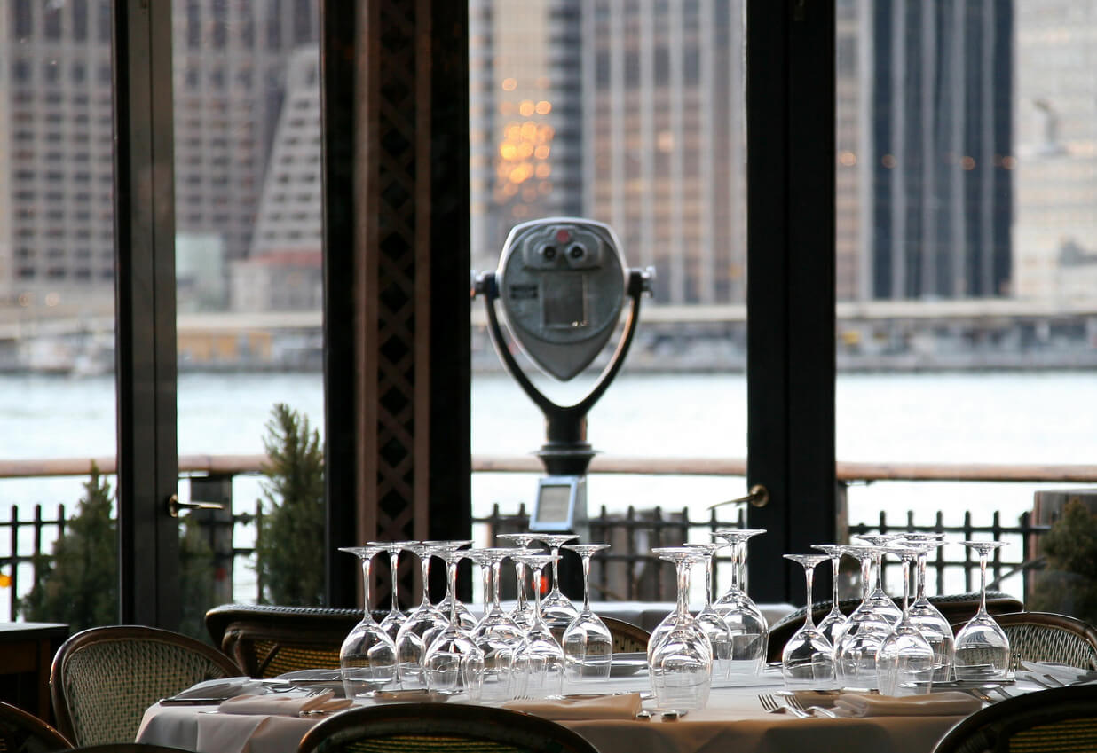 Dining table with wine glasses in a restaurant, symbolizing the recovery in NYC's retail sector.
