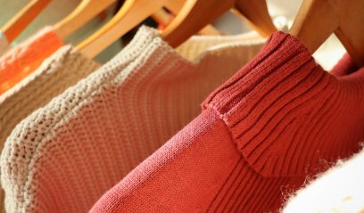 Cozy sweaters on hanger, a nod to fashion in NYC's Herald Square during the retail clash.