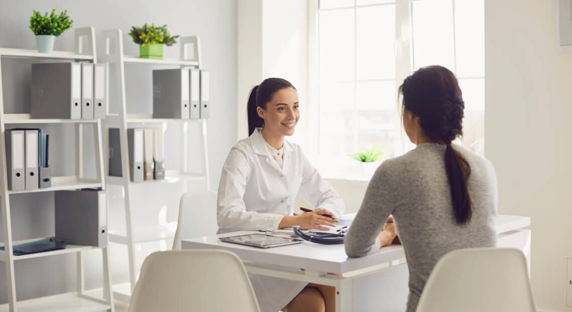 Smiling female doctor consults patient at Manhattan medical office.