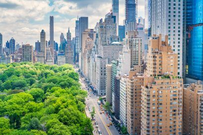 Manhattan skyline viewed from above on a sunny day, reflecting Mayor Adams' impact on NYC commercial real estate.