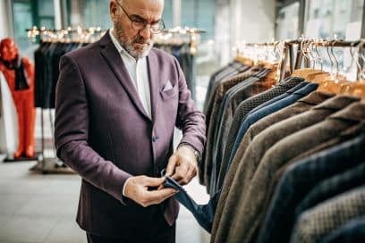 NYC Fashion Showroom: Businessman Trying on Suit in Store.