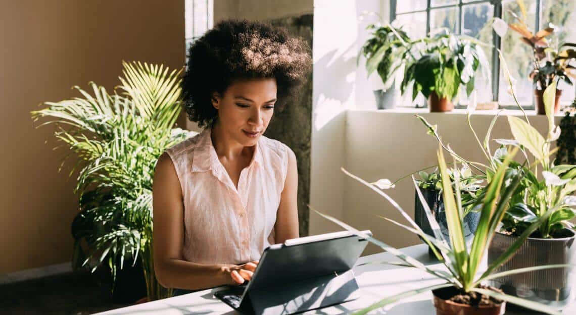 Businesswoman in a green office space, embodying sustainability in NYC's commercial real estate.