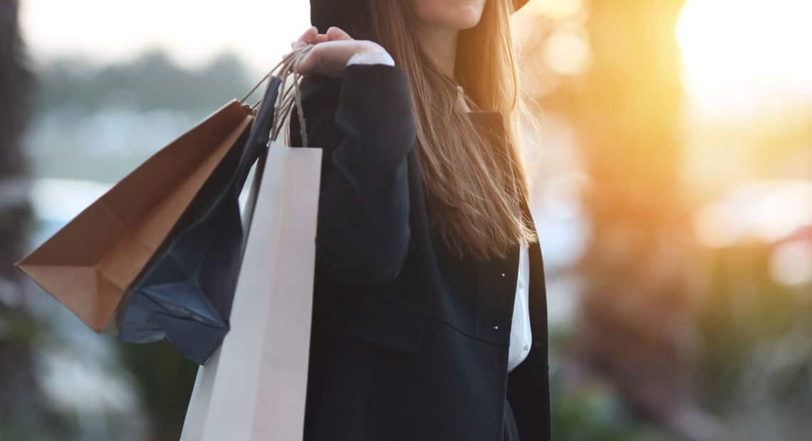 Stylish shopper with bags browses NYC luxury boutiques.