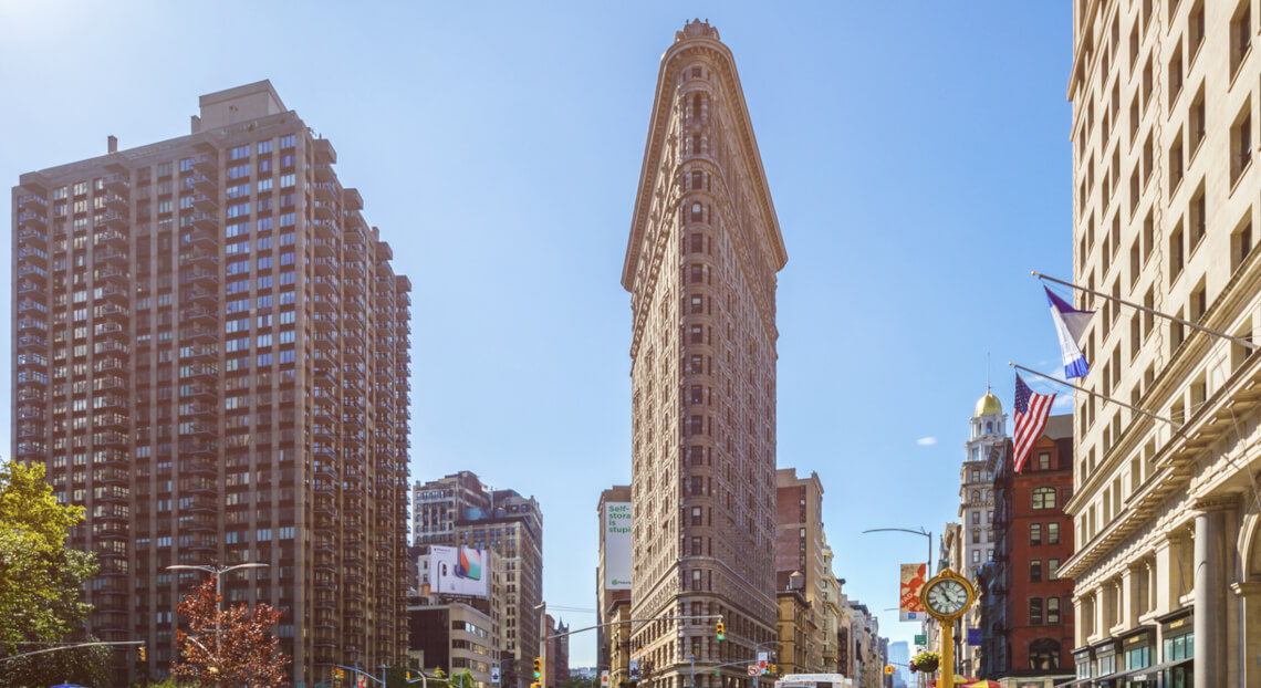 Morning view of Flatiron Building and NYC skyline near Madison Square Park.