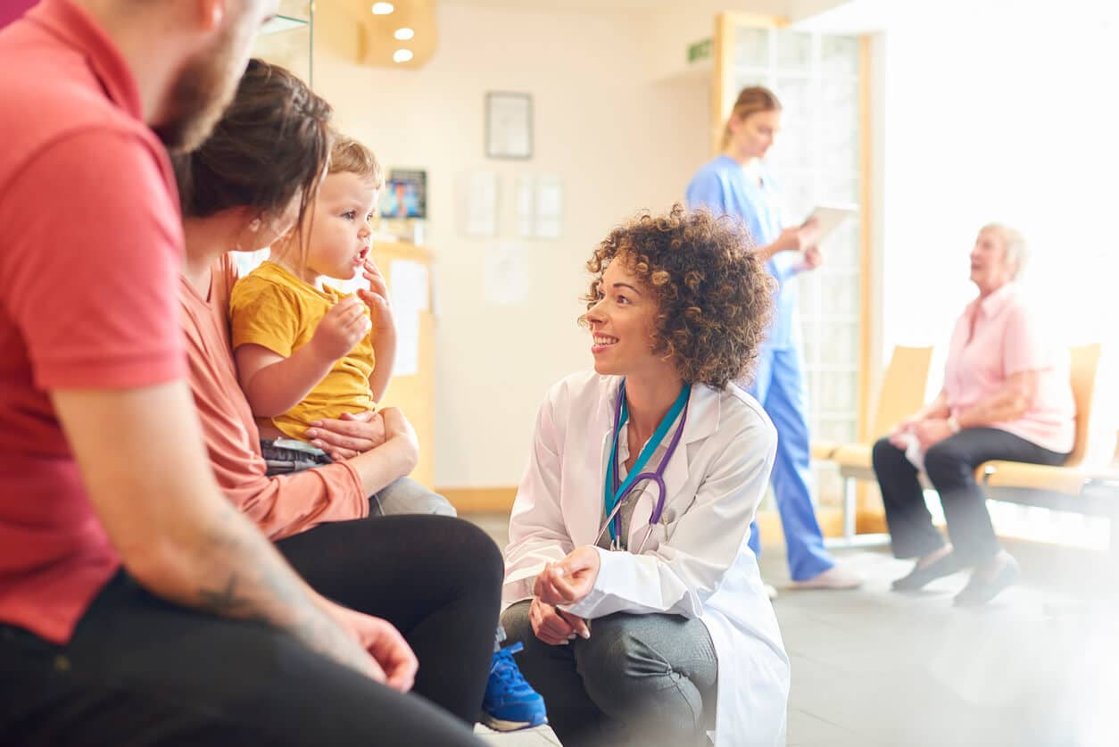 Young Female Doctor Consulting a Mother and her Child in a Doctor’s Waiting Room.