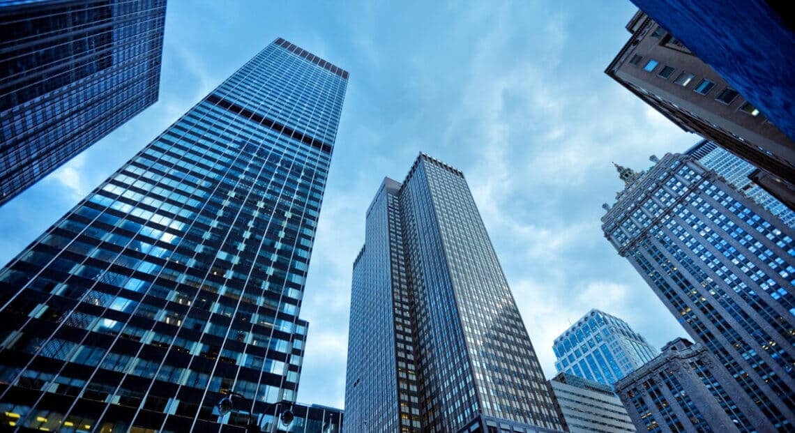 A photo of a row of skyscrapers in New York City, with the blue sky in the background.