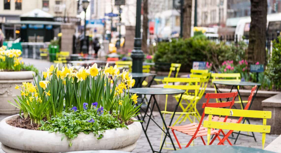 NYC Herald Square view with empty Greeley Square Park chairs near Koreatown.