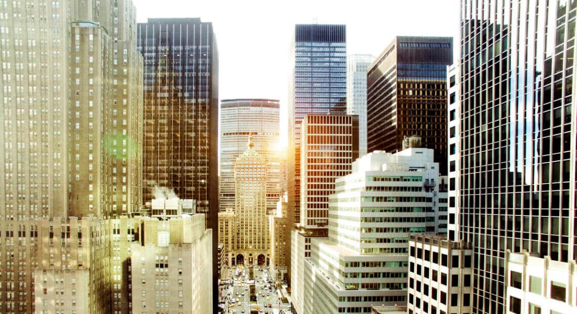 The famous Park Avenue street, in New York City on Manhattan Island, New York. The image shows a busy street in New York City, with skyscrapers on either side. The street is lined with luxury cars and taxis.