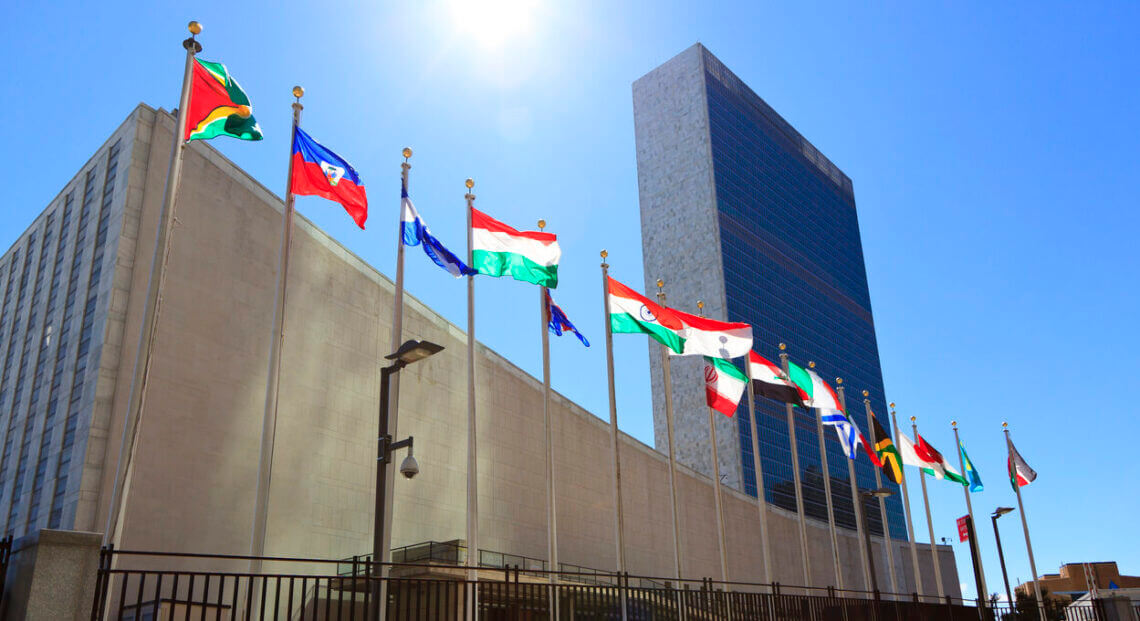 UN Headquarters in NYC with member states' flags waving.