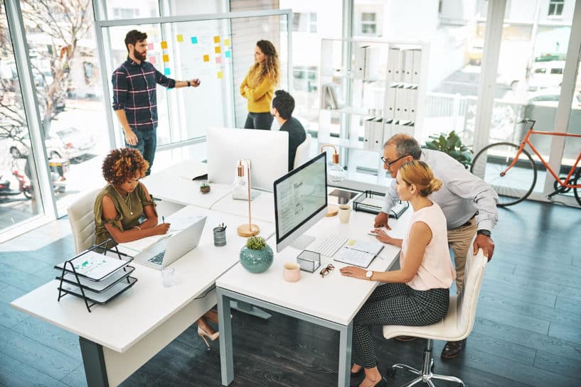 Ad agency team in a modern office: hardwood floors and exposed ceiling