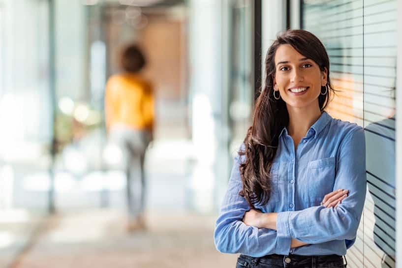 Young, attractive businesswoman in a subleased office smiling at the camera