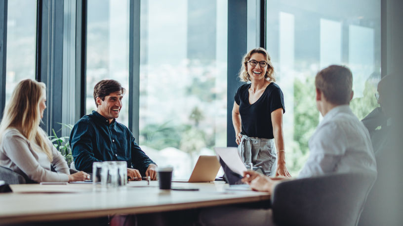 Colleagues discussing in a meeting; group in conference room smiling