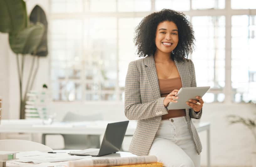 Happy businesswoman using a digital tablet in a Manhattan coworking office.