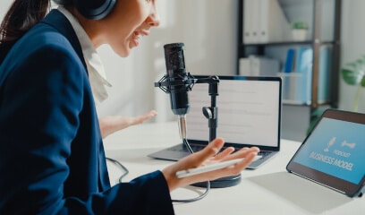 NYC businesswoman hosts podcast from sleek office studio.