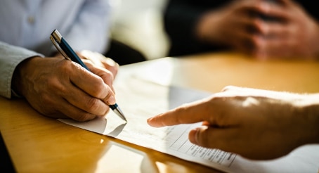 Businesswoman signing NYC office lease contract with real estate agent