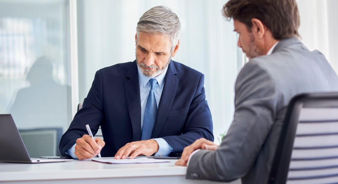 Businessman signing office documents - Good Guy Clause in NYC Commercial Lease