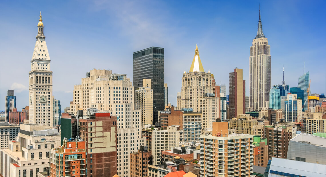 NYC skyline, Midtown Manhattan—signs of office market revival against a vivid blue sky.