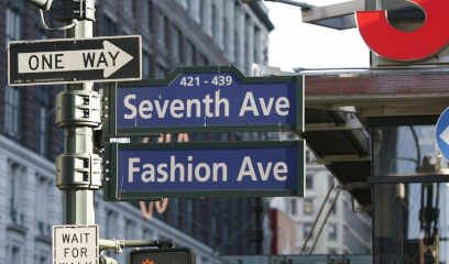 7th and Fashion Ave signs in Garment District, prime office space for rent in NYC's fashion hub.