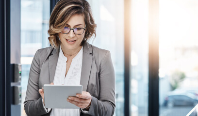 Businesswoman using a digital tablet in a sleek office, focusing on office leasing strategies.