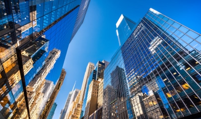 Luxurious NYC skyscrapers, epitome of skyline elegance, under blue sky.