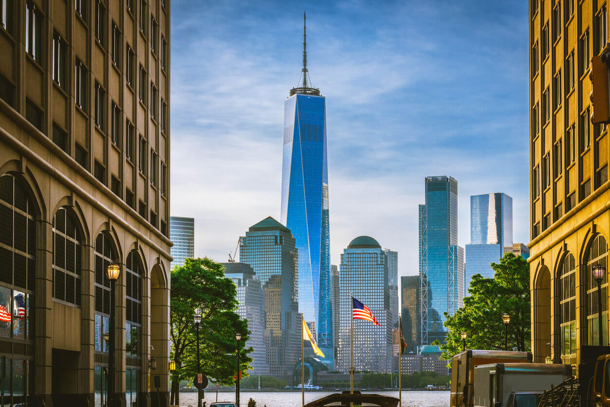 Freedom Tower with American flag in foreground, symbolizing resilience in NYC's office market.