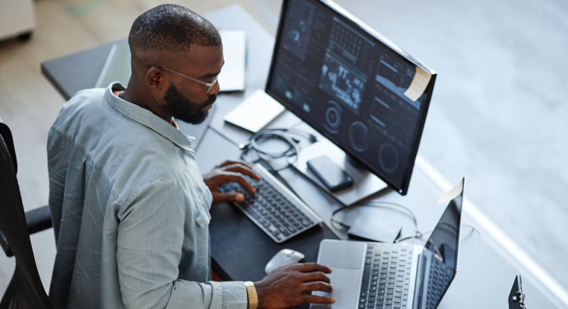 High angle view of African American software developer in NYC tech office