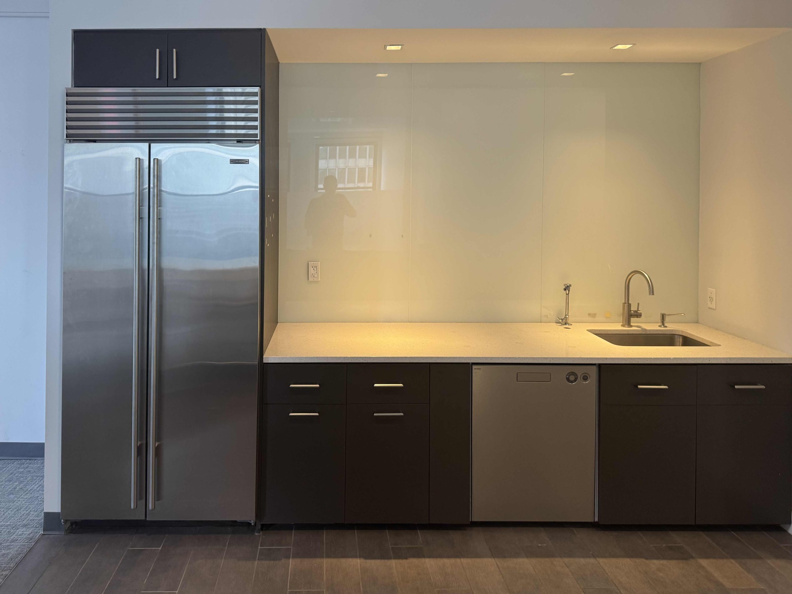 Modern kitchen on 33rd floor with sleek appliances and white counters.