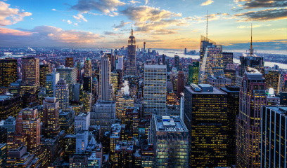 NYC skyline at sunset with Empire State Building and colorful clouds.