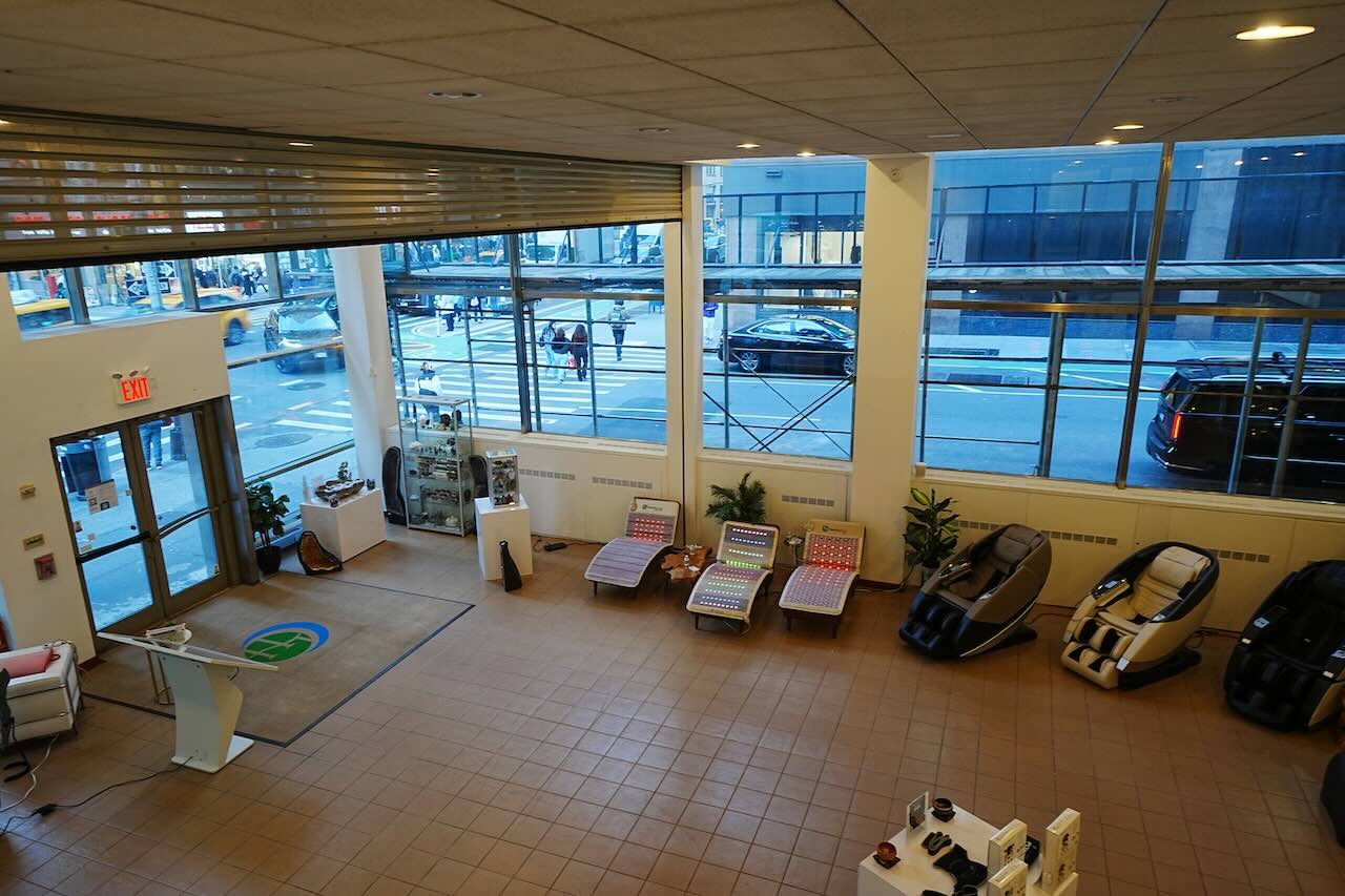 Showroom at 515 Seventh Ave with massage chairs, loungers, large windows, tiled floor, reception desk, and potted plants by entrance.
