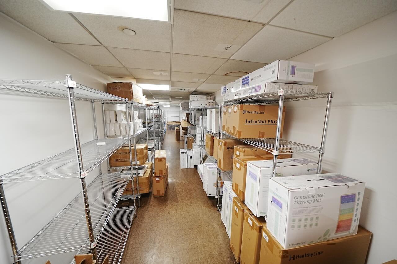 Storage room with metal shelves, cardboard boxes, and white ceiling tiles.