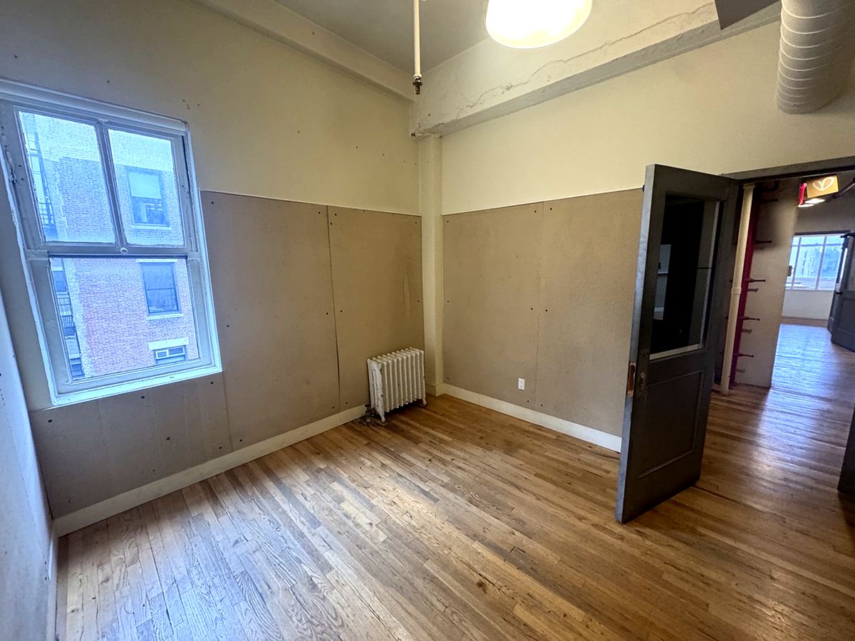 Open bullpen with glass partition and hardwood floors, 12th floor at 7 West 30th Street