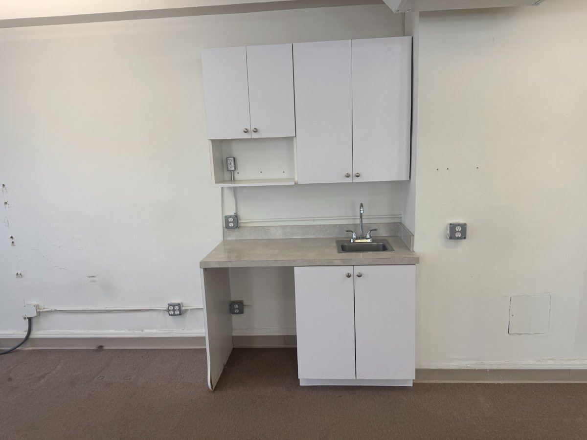 Small kitchenette with white cabinets and sink, 315 Madison Avenue #1201