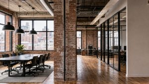 Modern office: exposed brick, big windows, wood floors, city views.