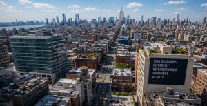 NYC aerial, skyscrapers, busy street, building with bold sign.