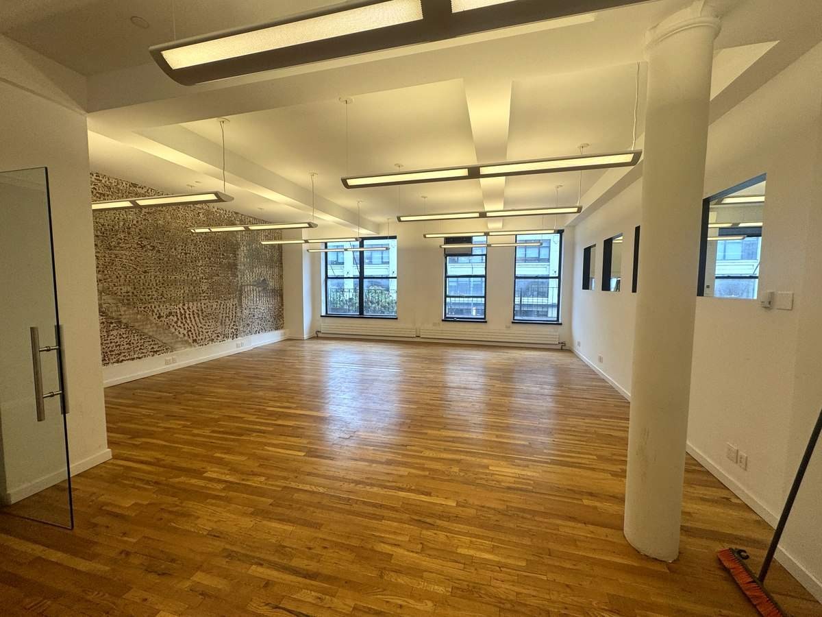 Bullpen with exposed brick wall and glass door, Suite 2N at 420 West 14th Street